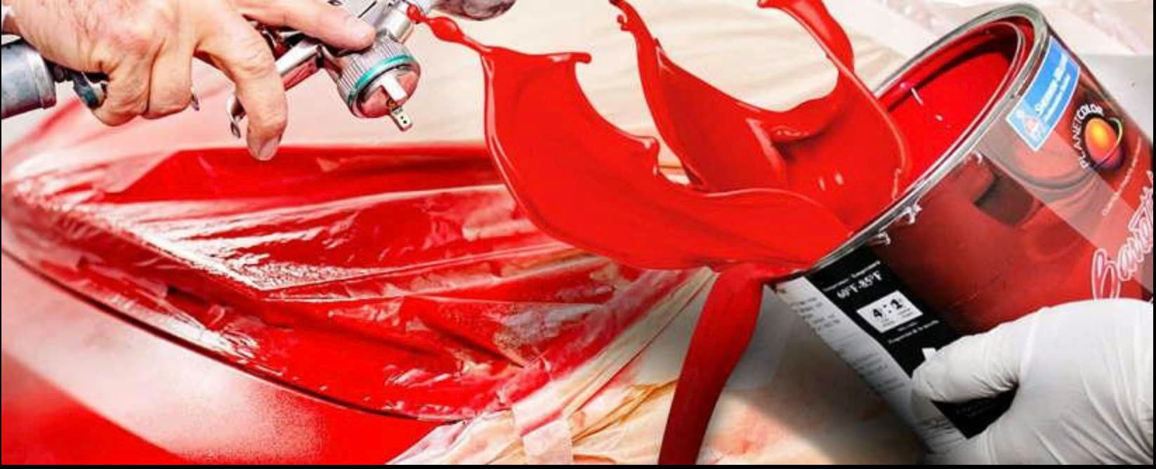 Spray gun applying bold red paint to a custom vehicle panel
