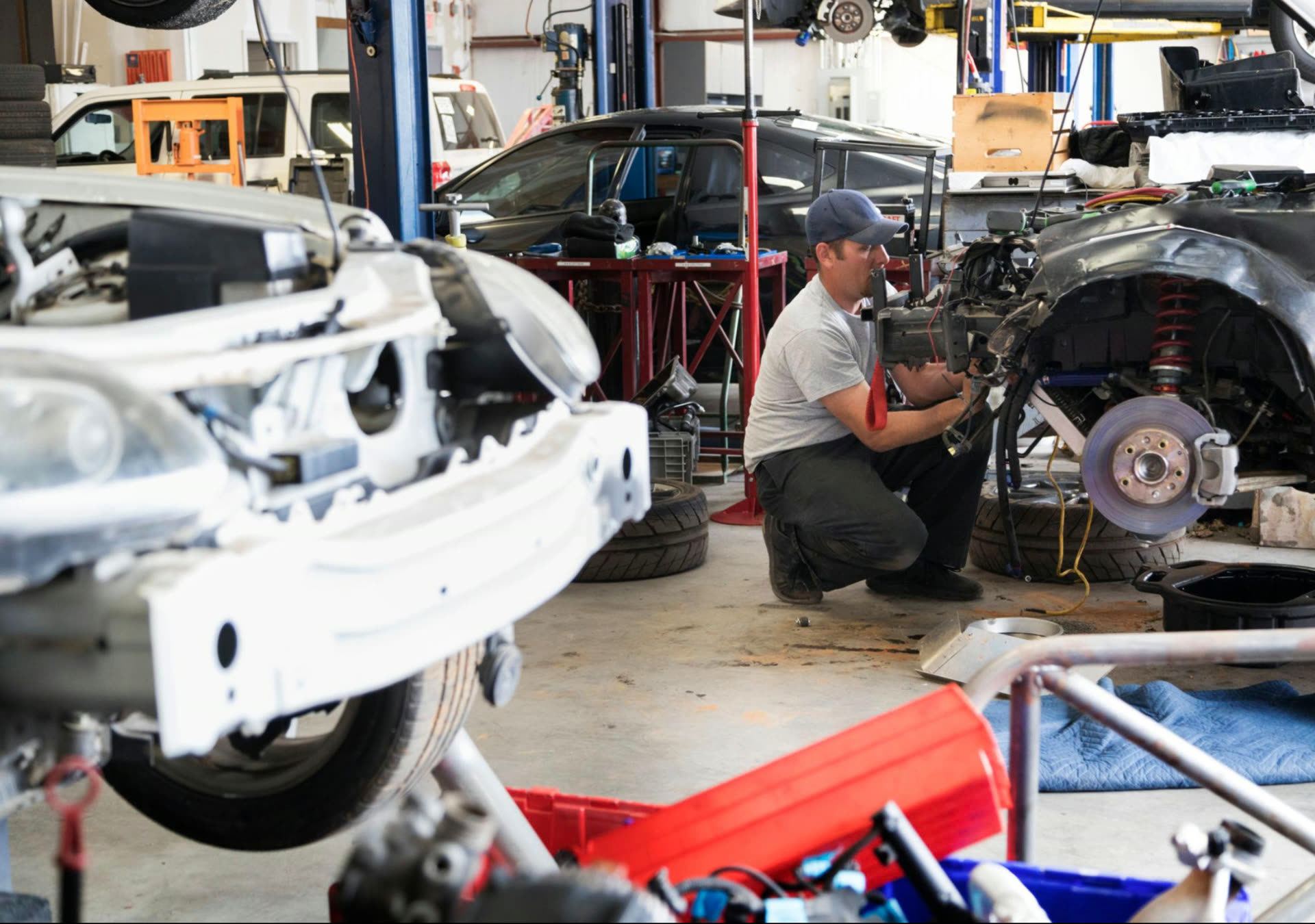 Body shop floor with multiple vehicles being repaired